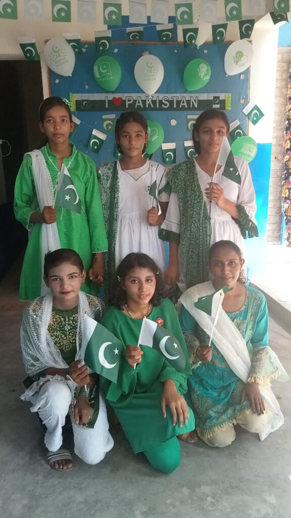 Schülerinnen in den Nationalfarben von Pakistan mit Nationalflaggen.