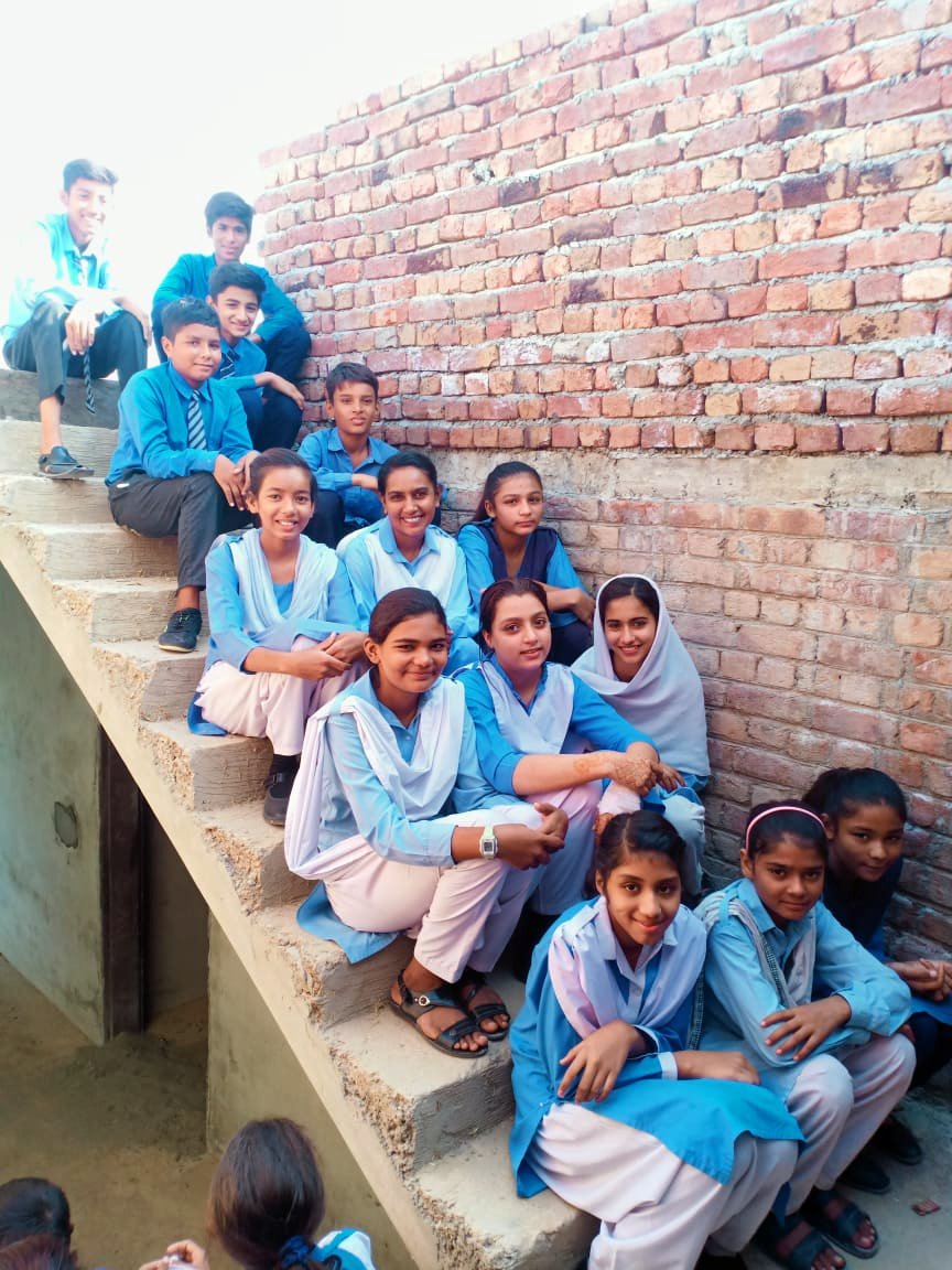 Completed stairs with 14 school girls and boys sitting on the steps.