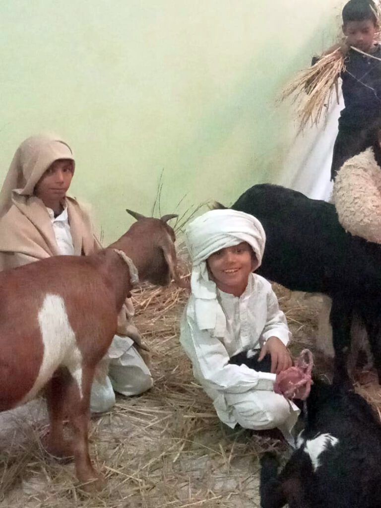 3 students dressed as shepherds with 3 goats