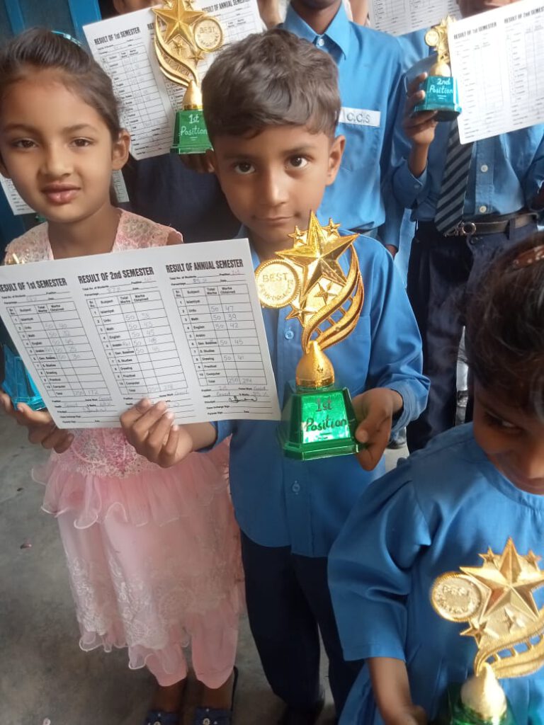 A student among other students showing his result sheet and trophy.