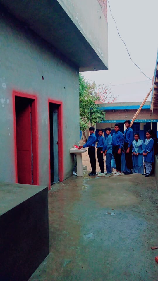 group of students queuing in front of a washbasin outside of the new bathrooms.